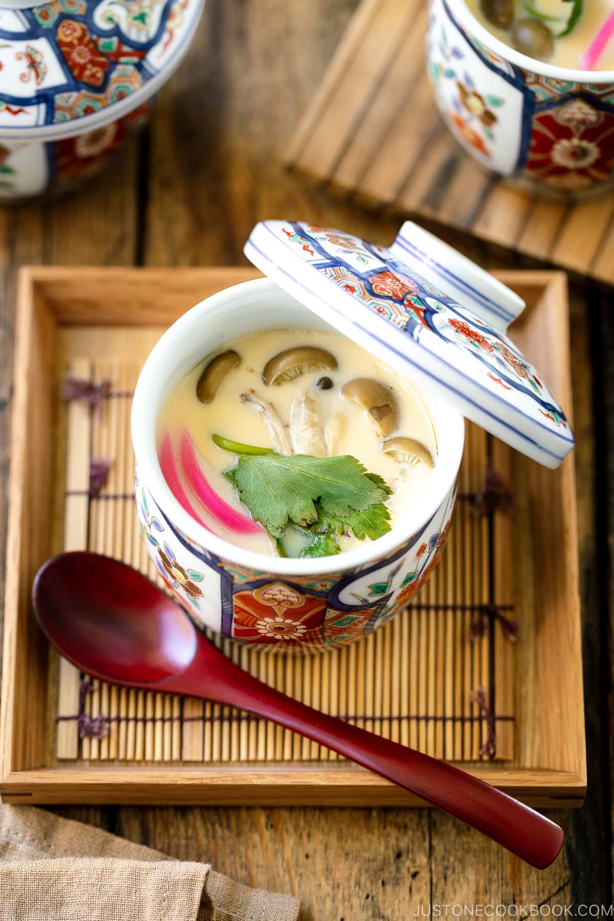 A special Japanese chawanmushi cup containing savory steamed custard filled with kamaboko fish cake, chicken, and mushroom.