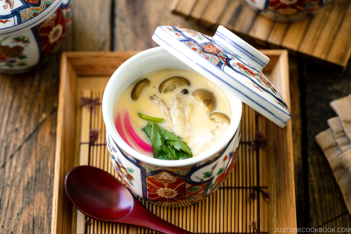 A special Japanese chawanmushi cup containing savory steamed custard filled with kamaboko fish cake, chicken, and mushroom.