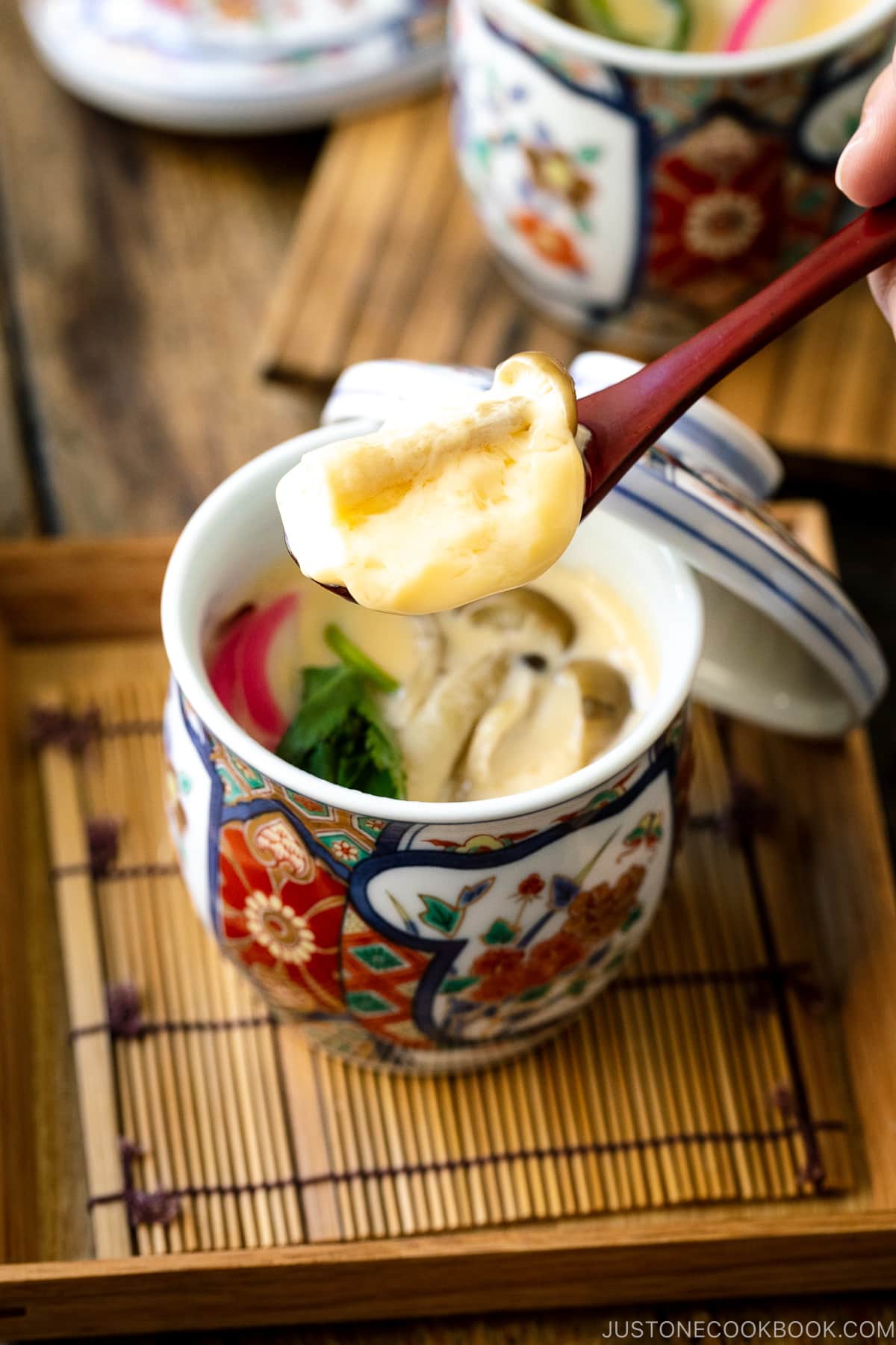 A special Japanese chawanmushi cup containing savory steamed custard filled with kamaboko fish cake, chicken, and mushroom.