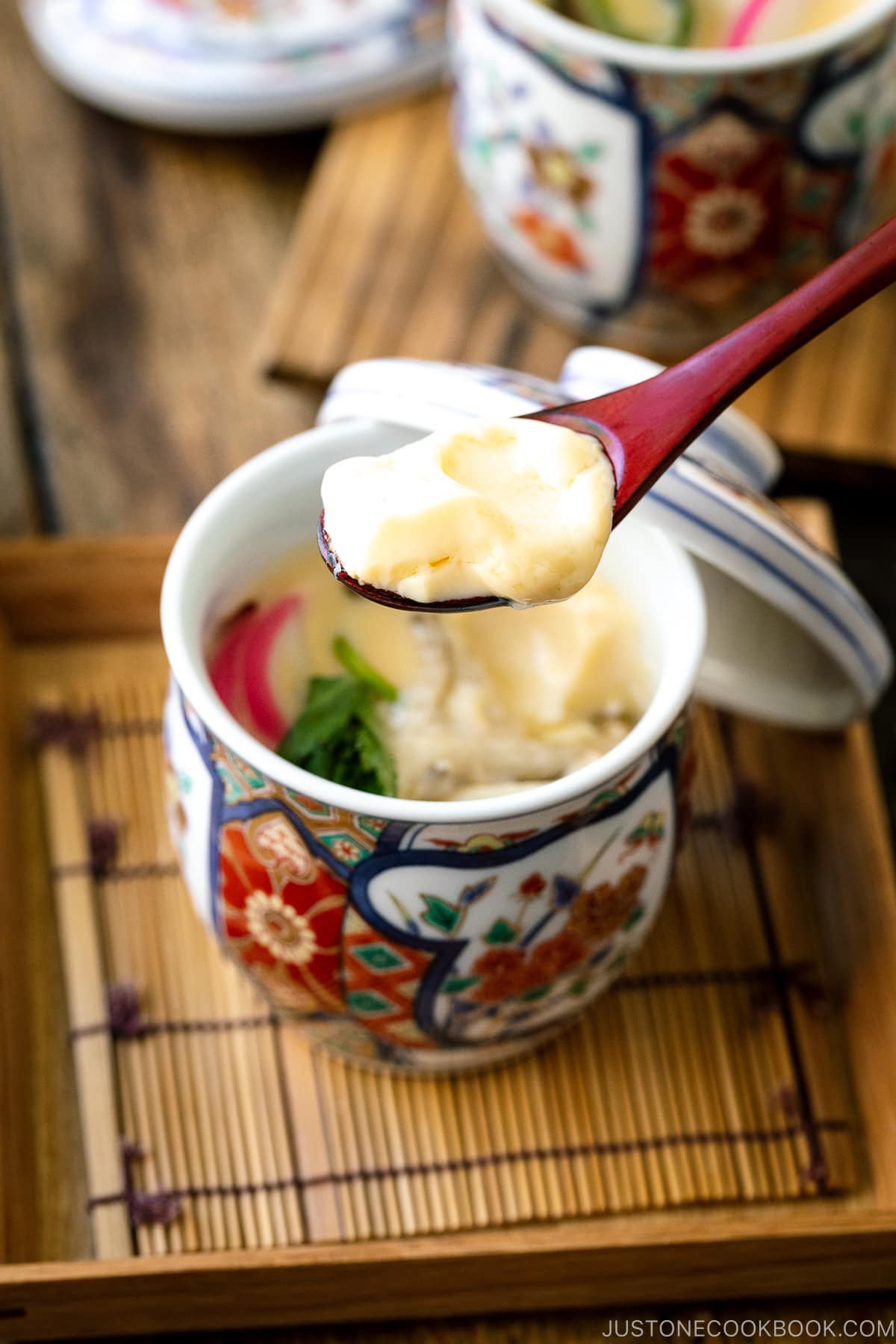 A special Japanese chawanmushi cup containing savory steamed custard filled with kamaboko fish cake, chicken, and mushroom.
