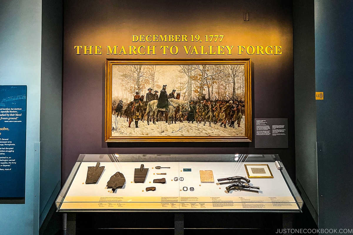 a painting below the words the march to valley forge