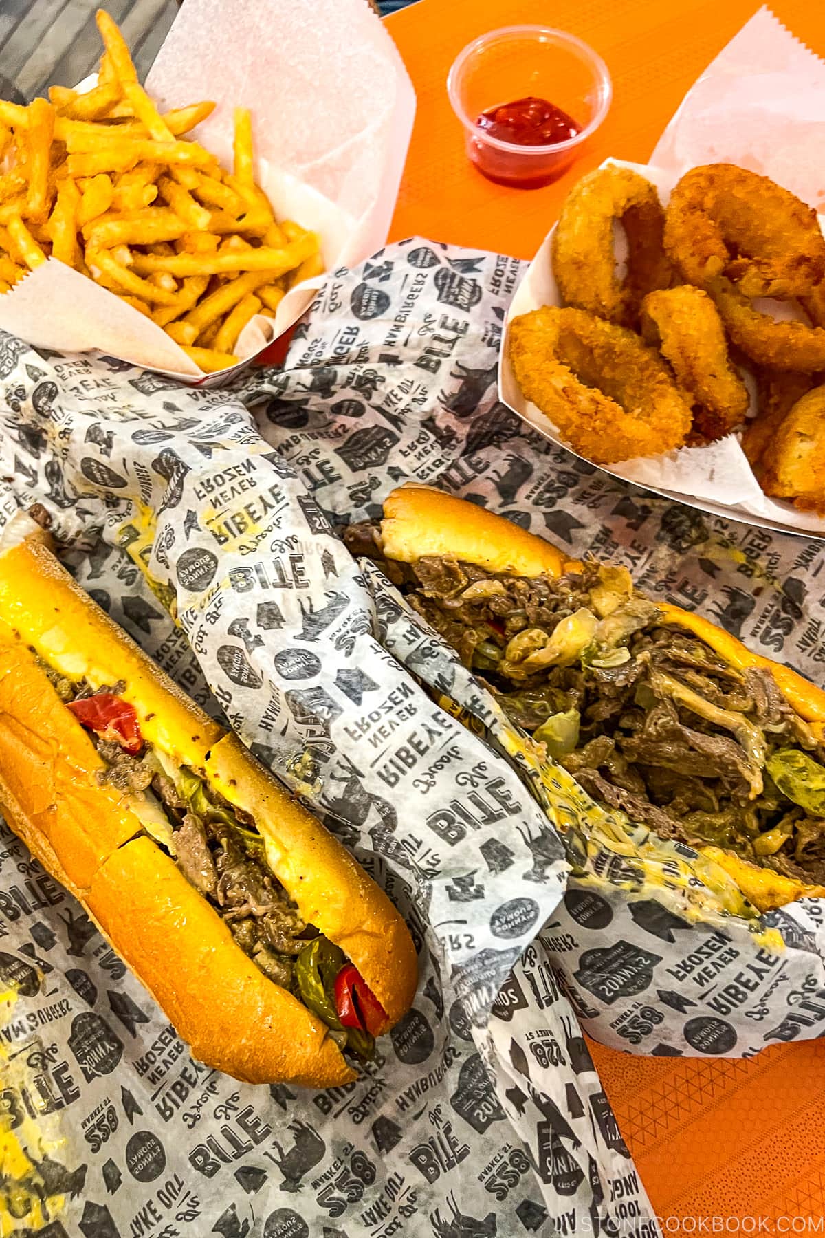 cheesesteak and fries on a table