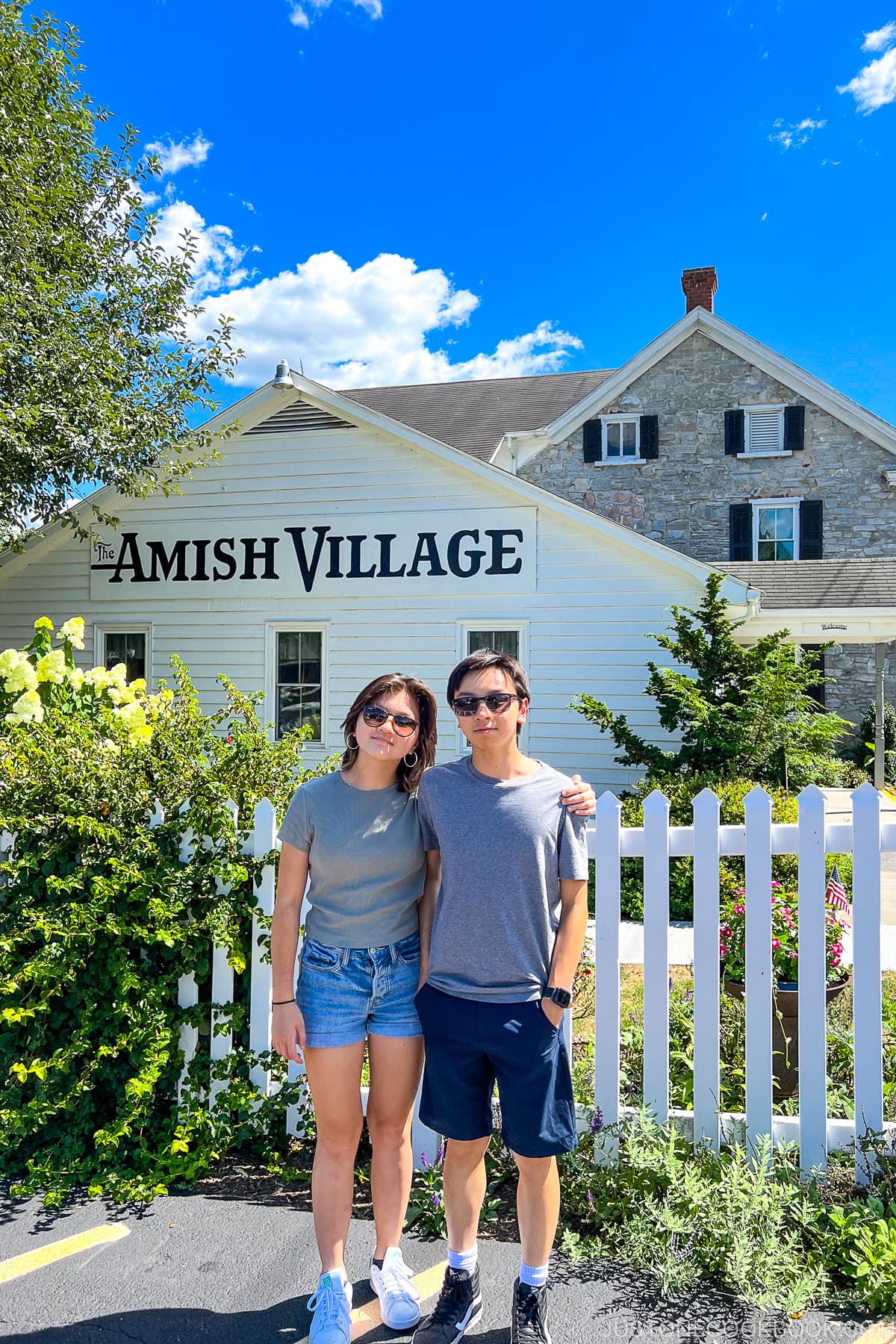 a boy and a girl standing in front of Amish Village