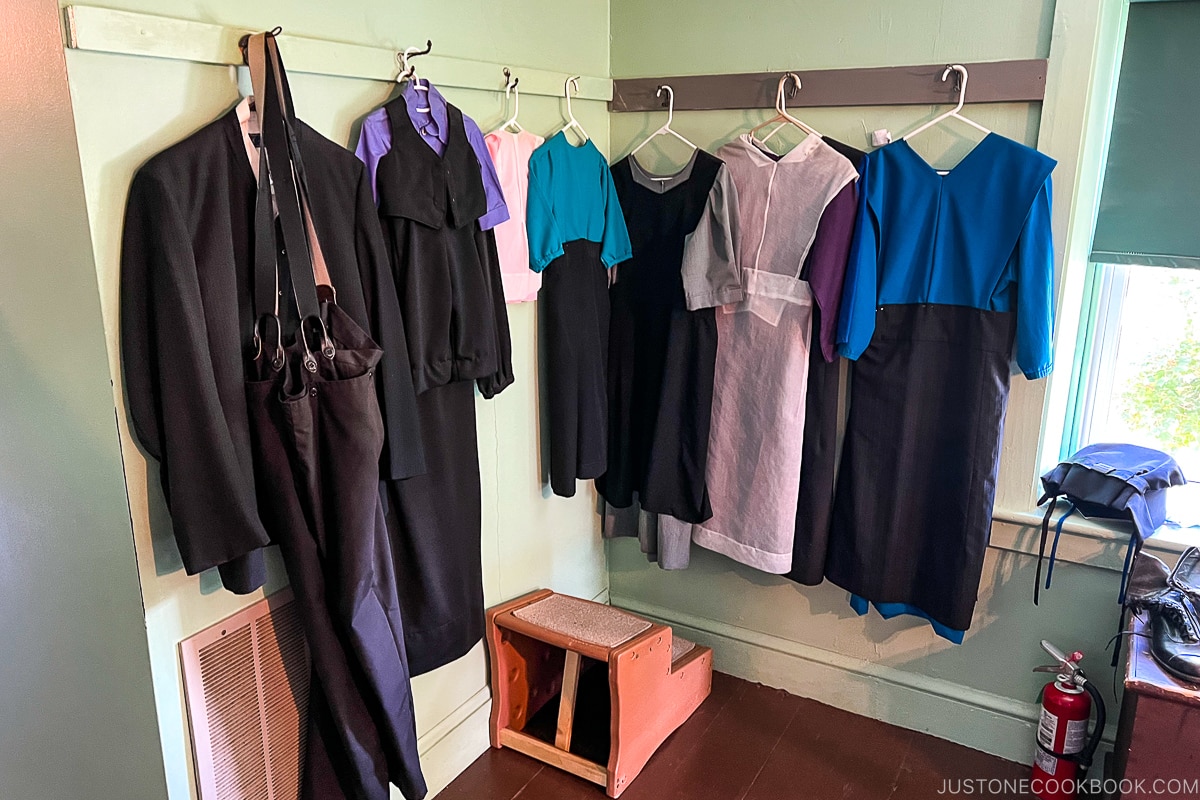 blue and white clothes hanging on wall hooks