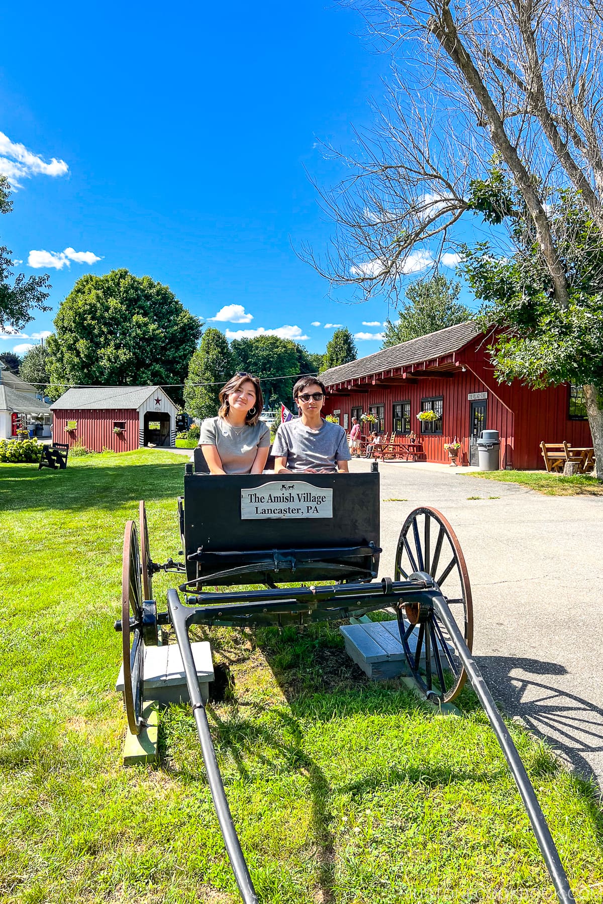 a boy and a girl sitting in a carriage