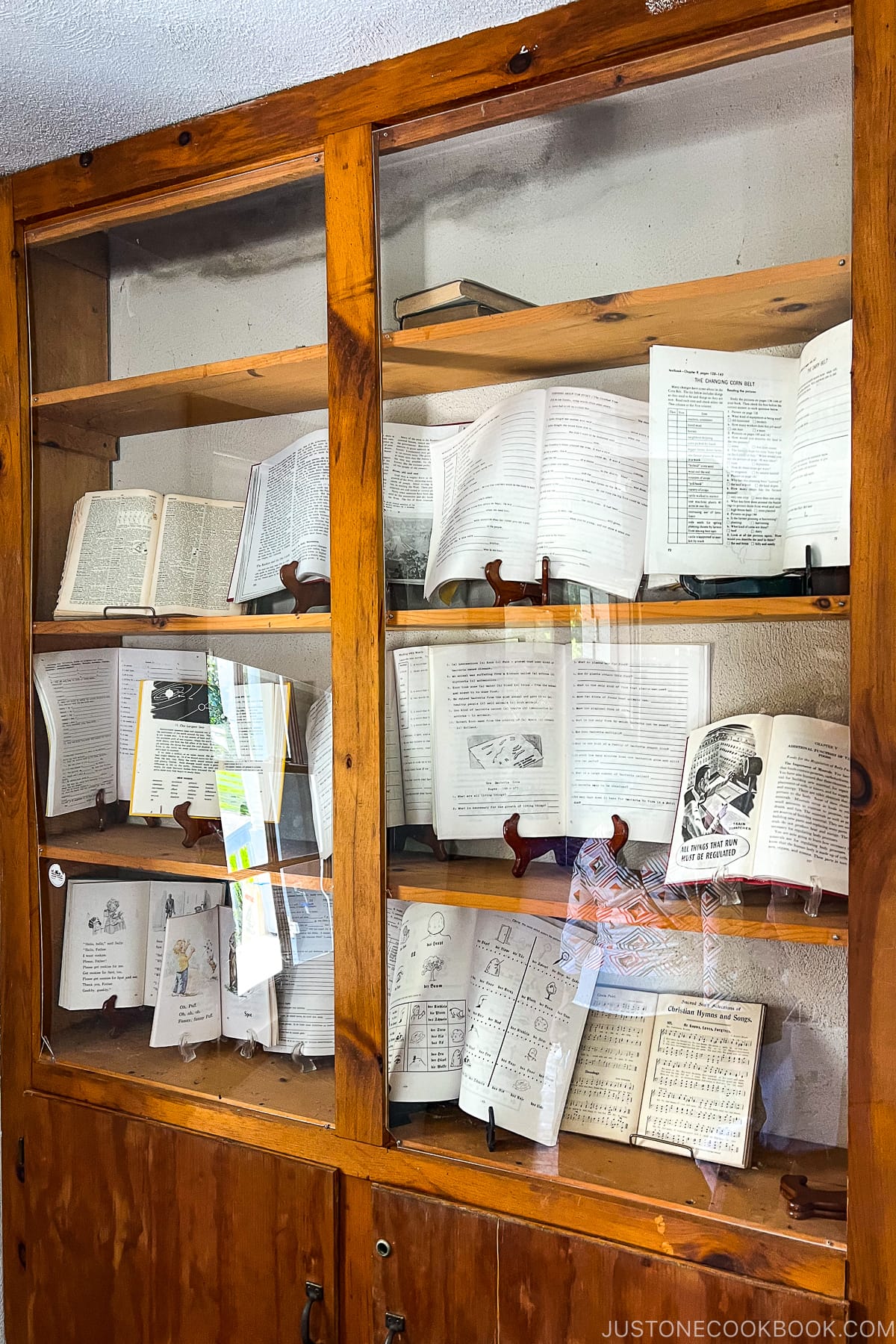 open books displayed in glass case