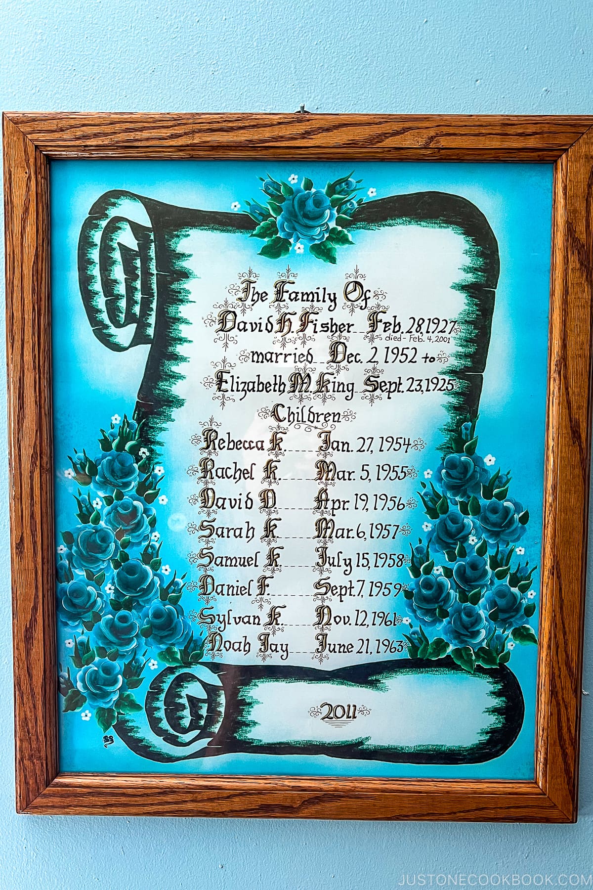 a frame paper with family members' names and birth dates