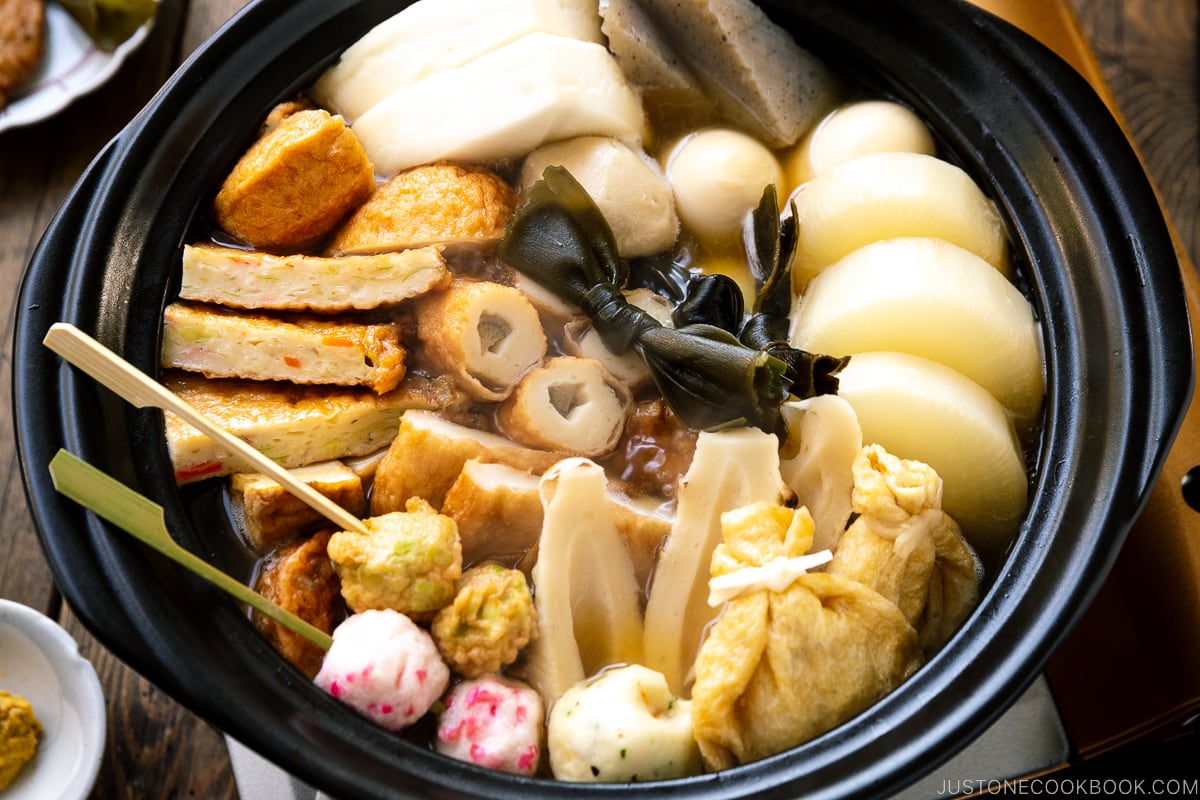 A donabe clay pot containing Japanese fish cake stew called oden, an assortment of fish balls and fish cakes.