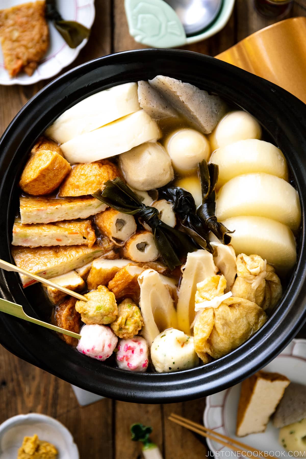 A donabe clay pot containing Japanese fish cake stew called oden, an assortment of fish balls and fish cakes.