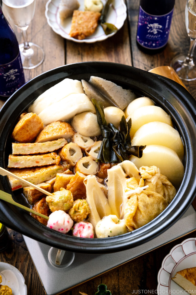 A donabe clay pot containing Japanese fish cake stew called oden, an assortment of fish balls and fish cakes.