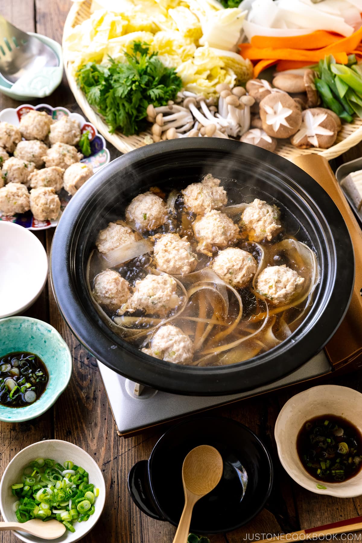 A Japanese clay pot simmering chicken meatballs in a savory dashi broth.