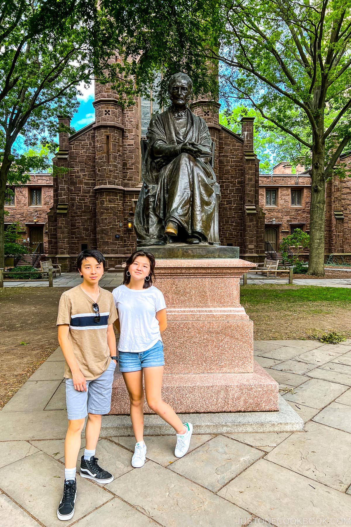 a boy and a girl next to statue