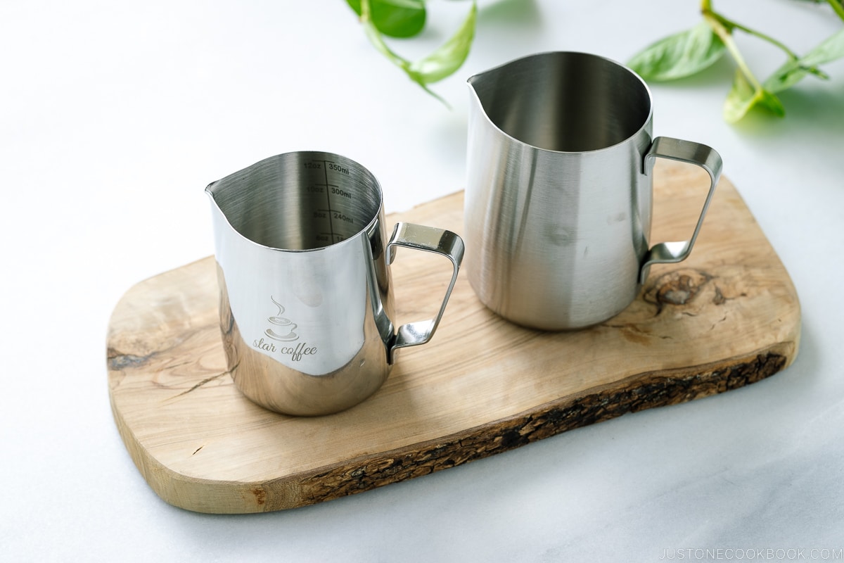 2 Milk Frothing Pitcher Jug on a wooden board