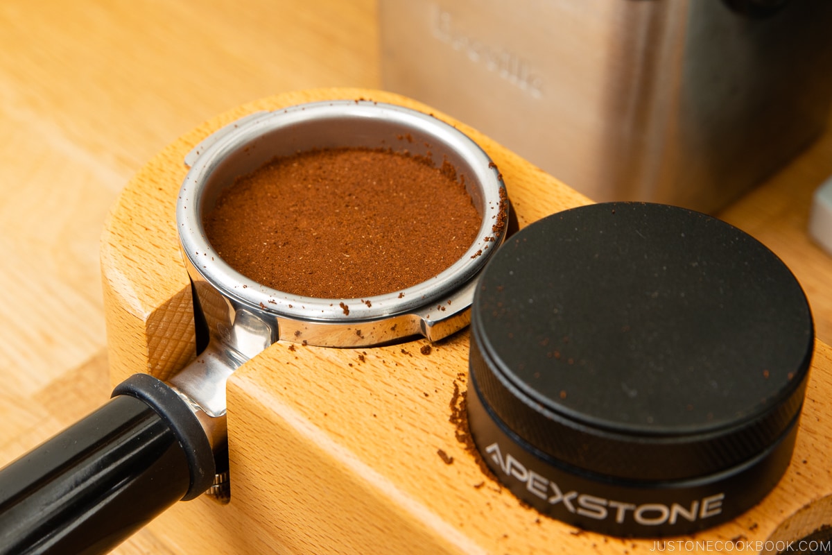 borras de café em um porta-filtro após compactação