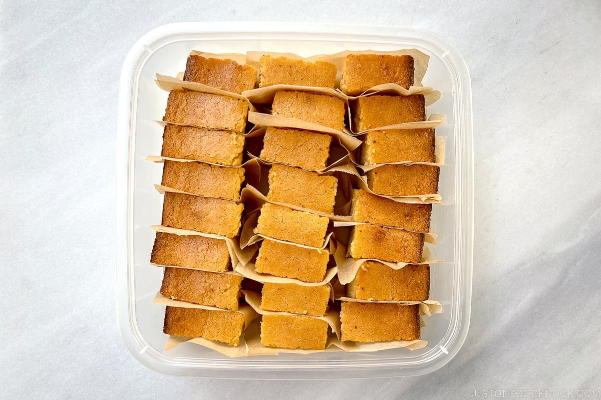 Butter mochi slices in a container.