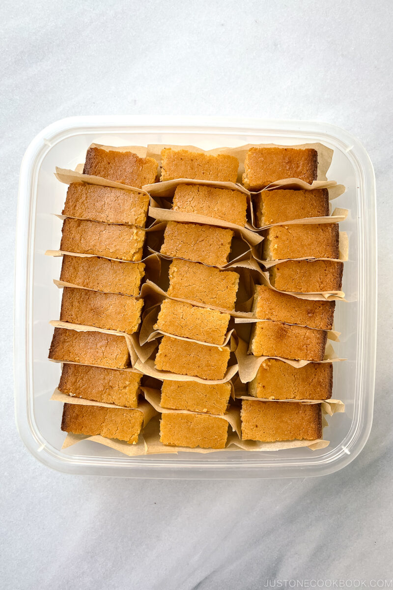 Butter mochi slices in a container.