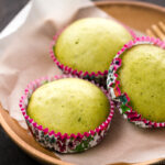 A wooden plate containing matcha green tea steamed cakes.