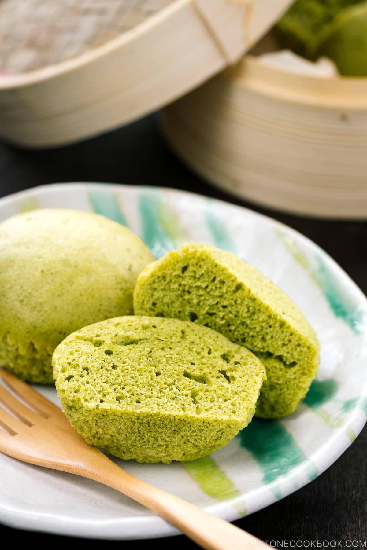 A white plate containing matcha green tea steamed cakes.