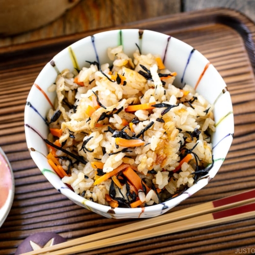 A rice bowl containing Hijiki Rice (Takikomi Gohan) served with pickles on the side.