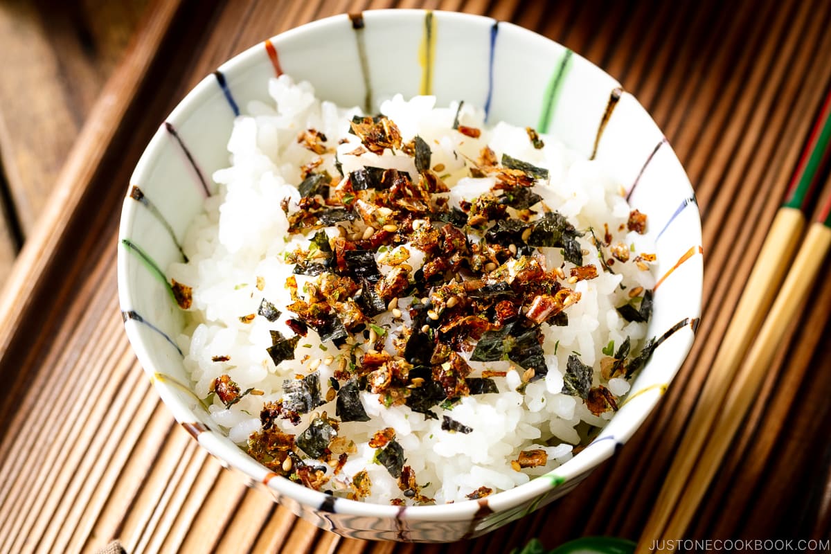 Una ciotola di riso contenente riso al vapore cosparso di condimento per riso furikake.