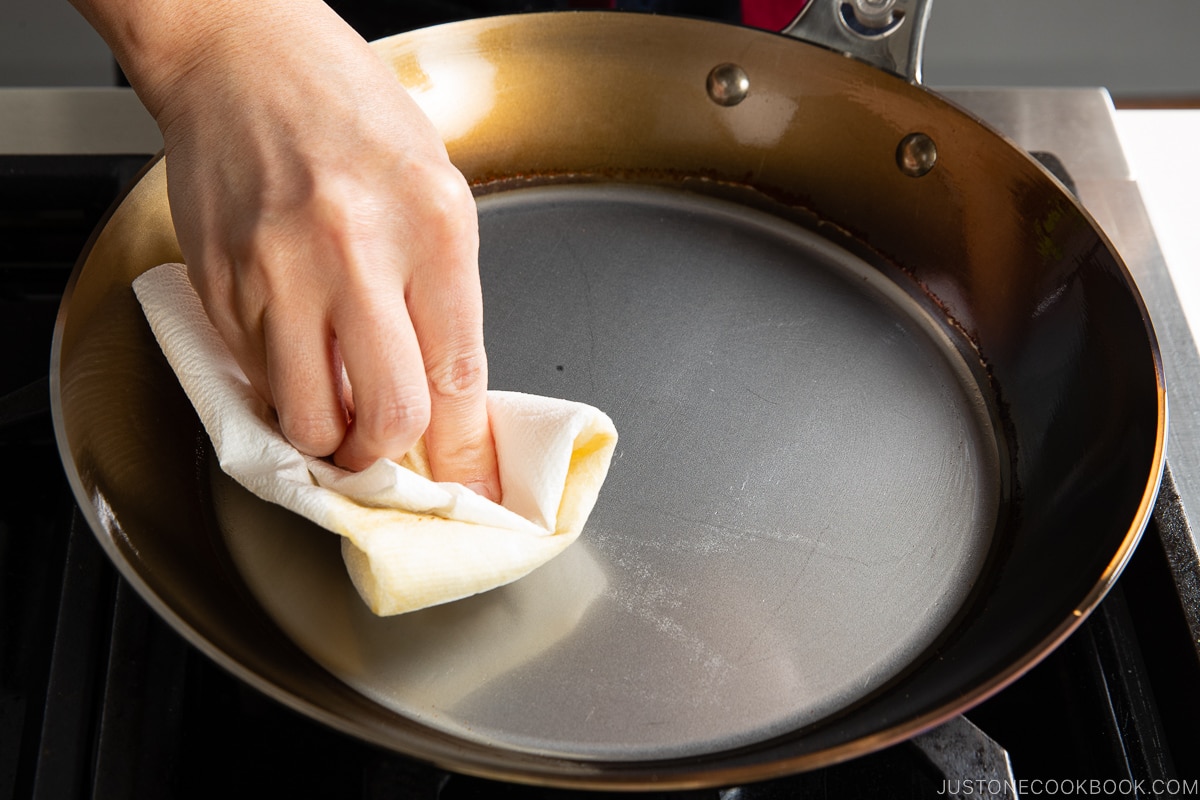 wiping oil from fry pan
