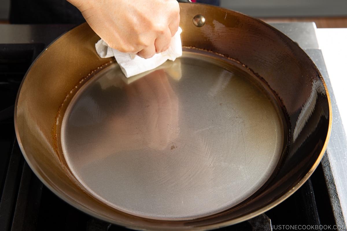 wiping oil on a carbon steel pan