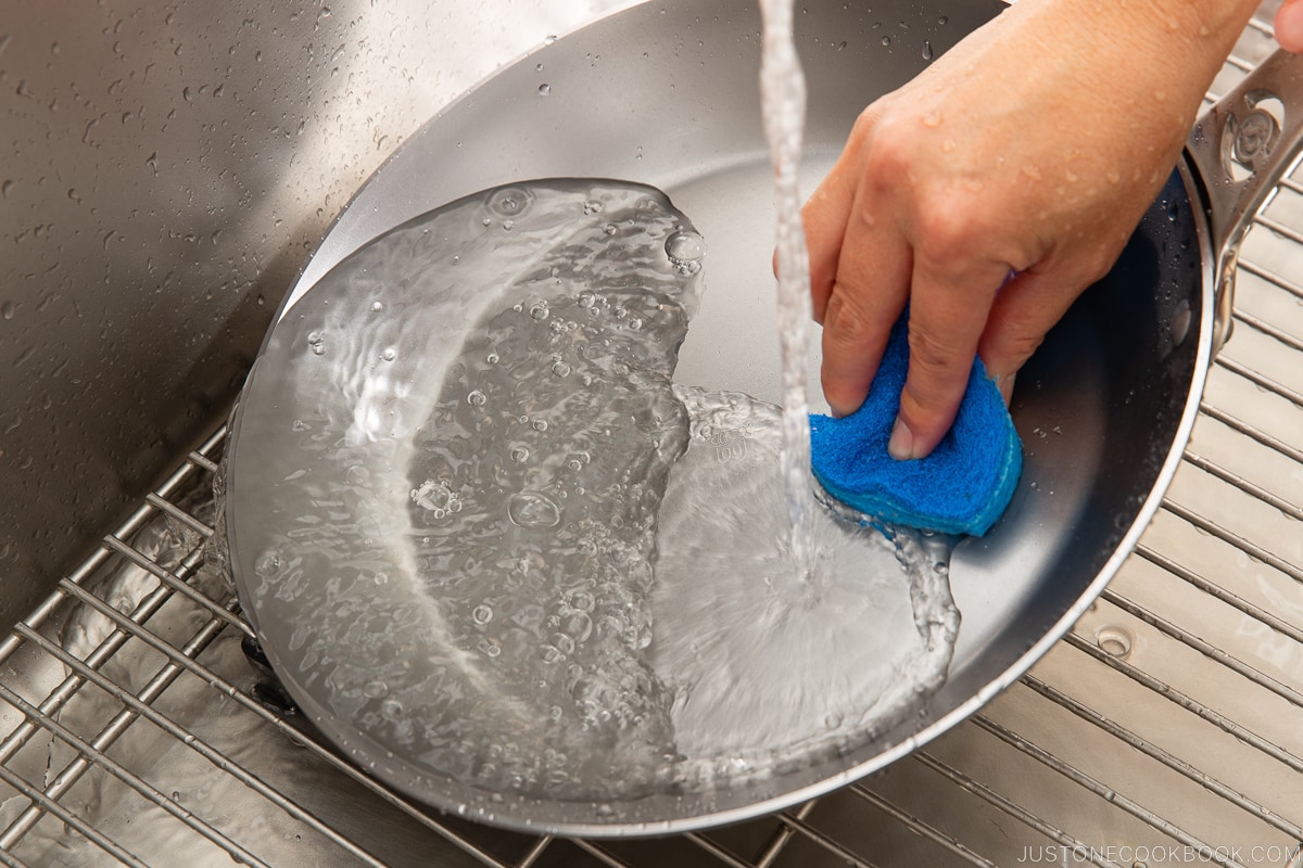 washing fry pan in sink