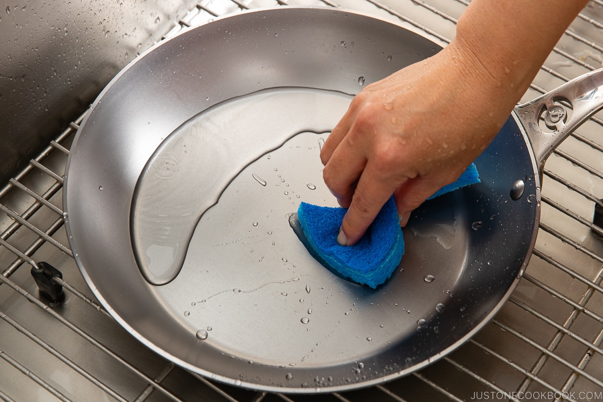 washing fry pan in sink