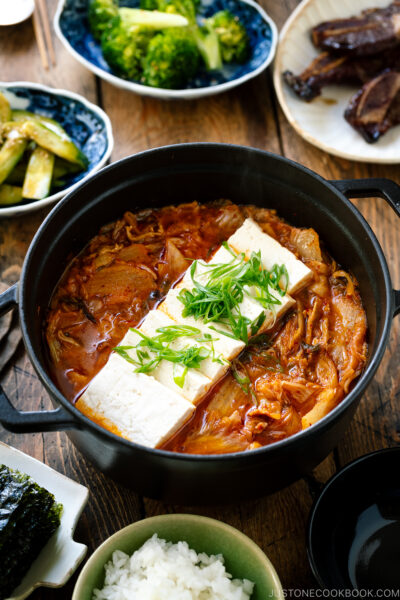 A shaded staub containing Kimchi Jjigae (Stew) topped with slices of tofu.  Gyudon (Crimson meat Bowl) Kimchi Jjigae Kimchi Stew 1702 II 400x600