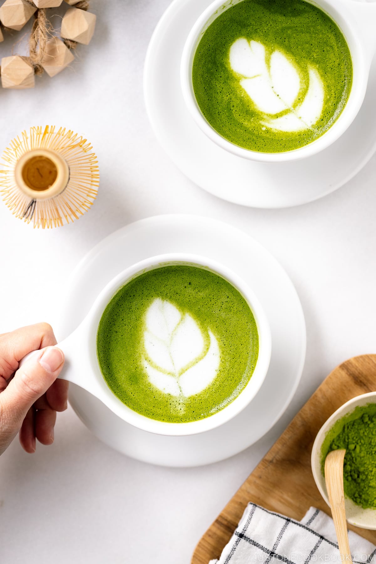 White cups containing Matcha Latte with a turip latte art.