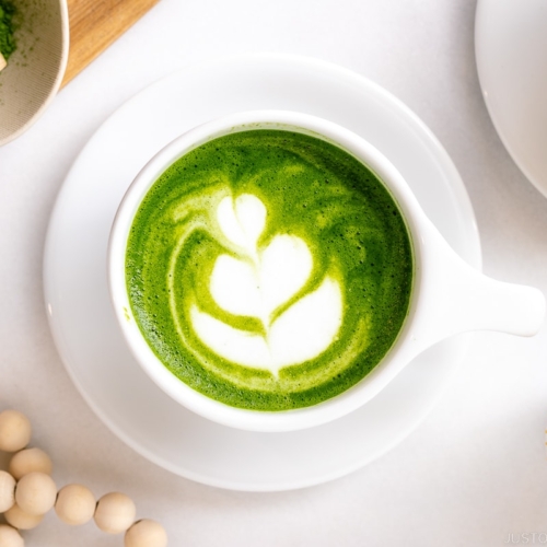 White cups containing Matcha Latte with a turip latte art.