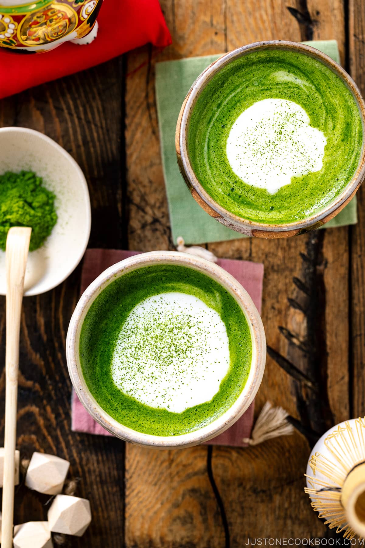 Japanese tea cups containing Matcha Latte with a flat white on top sprinkling with green tea powder.