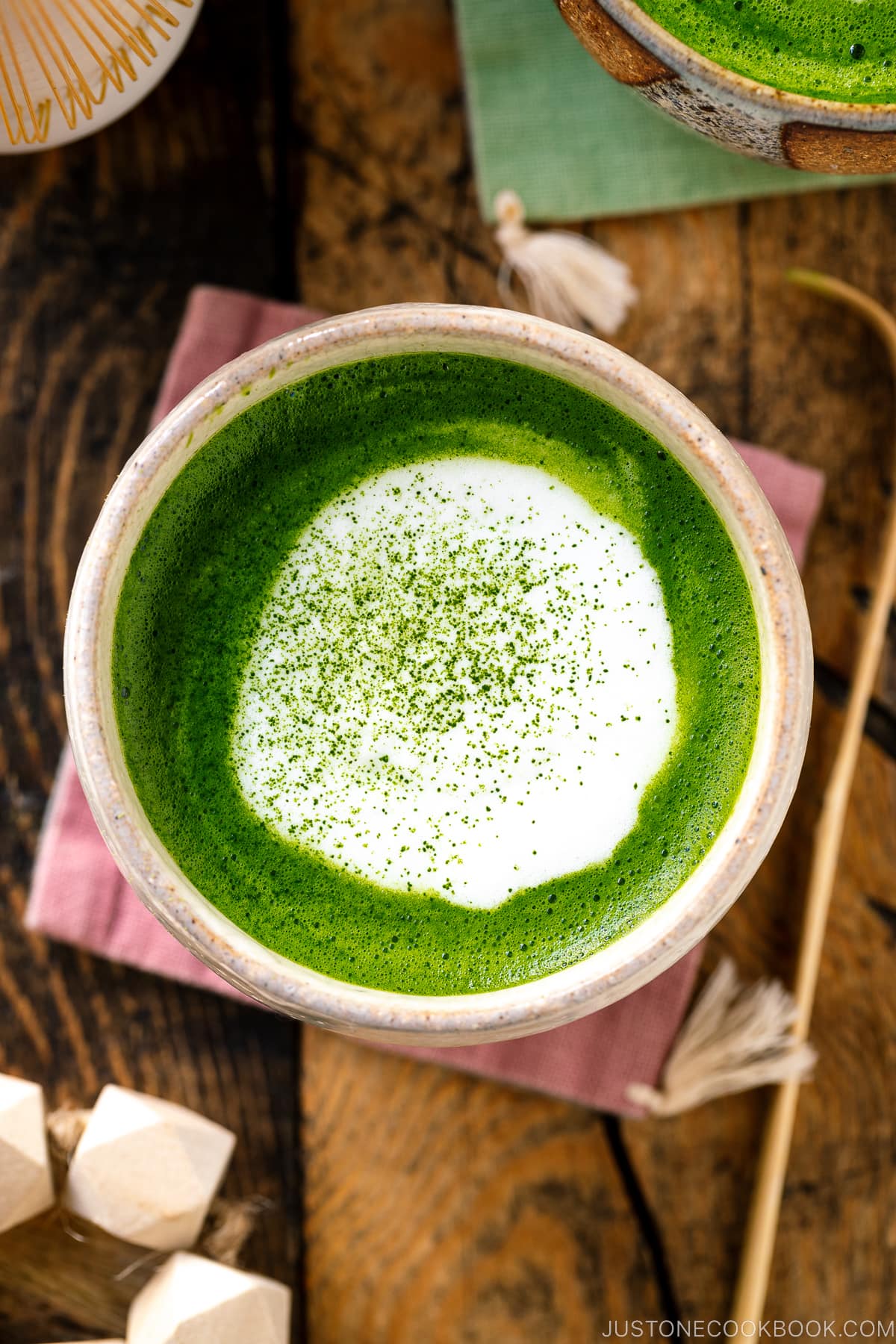 Japanese tea cups containing Matcha Latte with a flat white on top sprinkling with green tea powder.