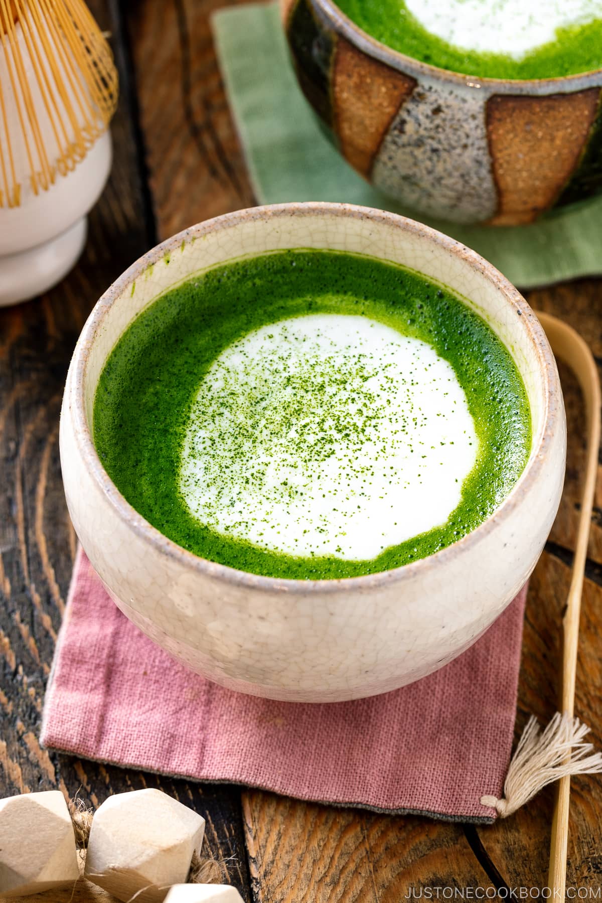 Japanese tea cups containing Matcha Latte with a flat white on top sprinkling with green tea powder.