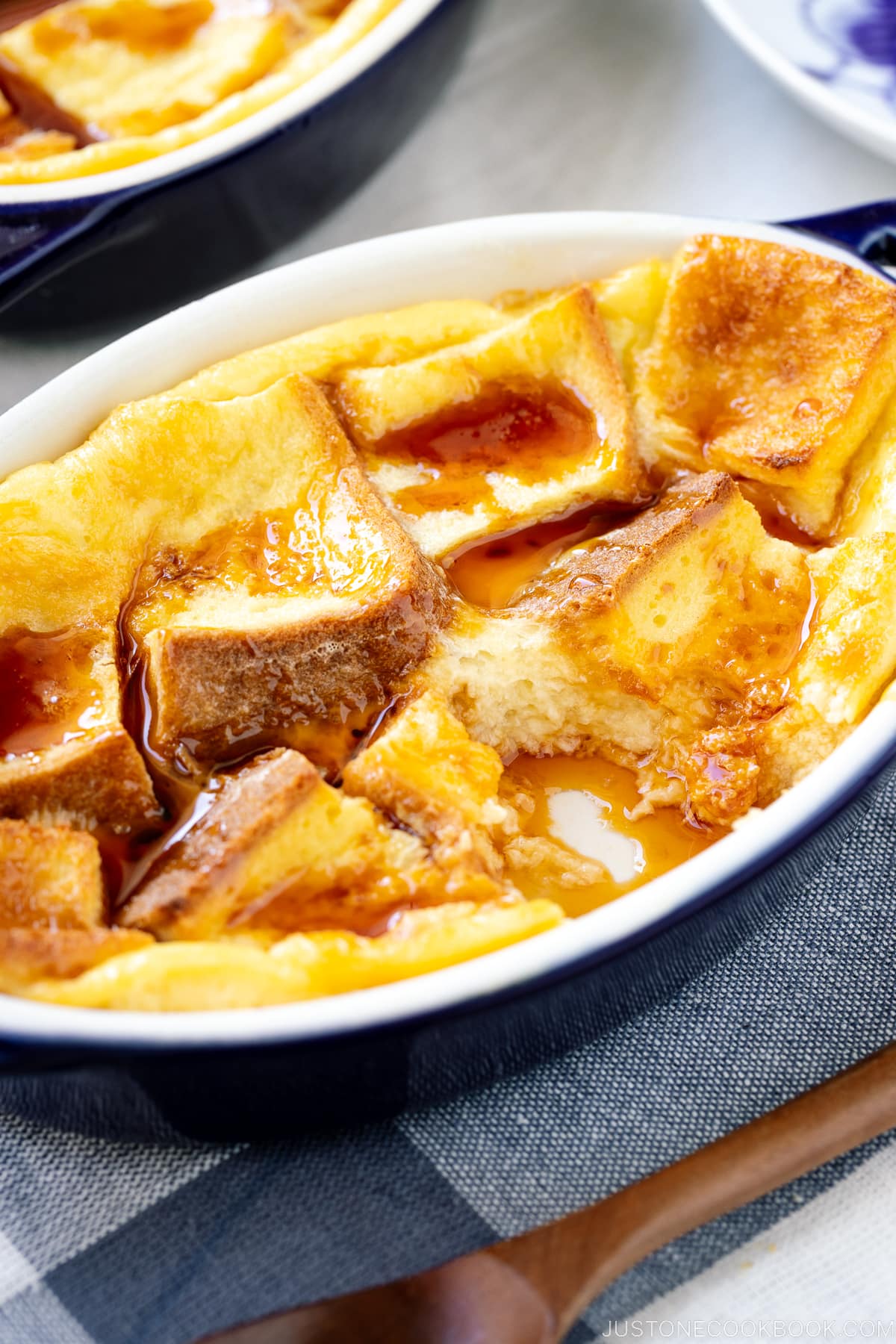 A gratin dish containing Pan Pudding (Japanese Bread Pudding) topped with a caramel sauce.