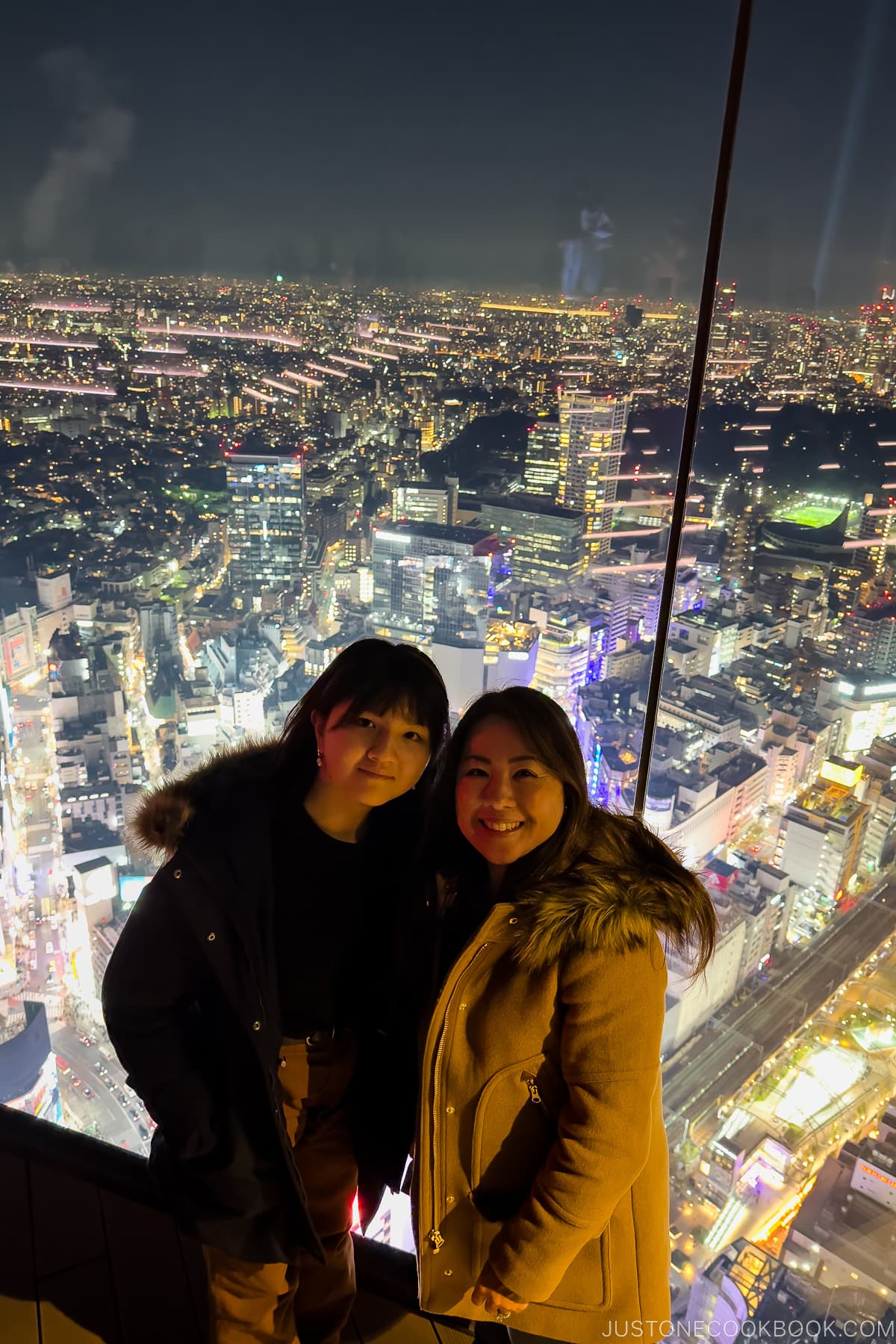 a girl and a women in front of a glass observatory wall