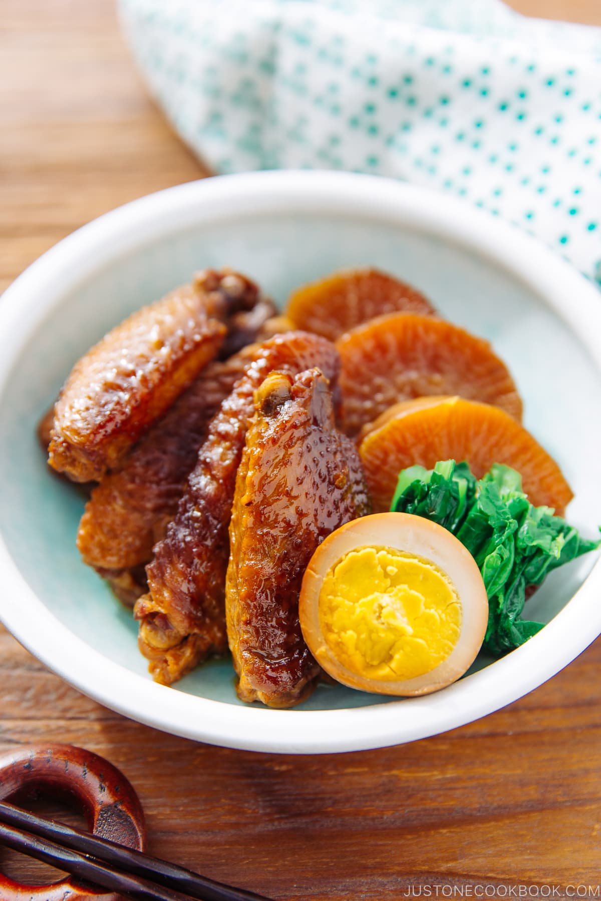 A plate containing slow cooker chicken wings along with daikon and eggs.