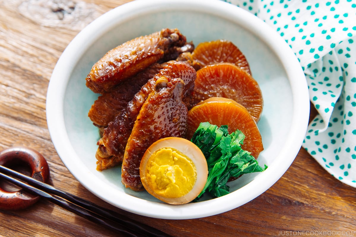 A plate containing slow cooker chicken wings along with daikon and eggs.