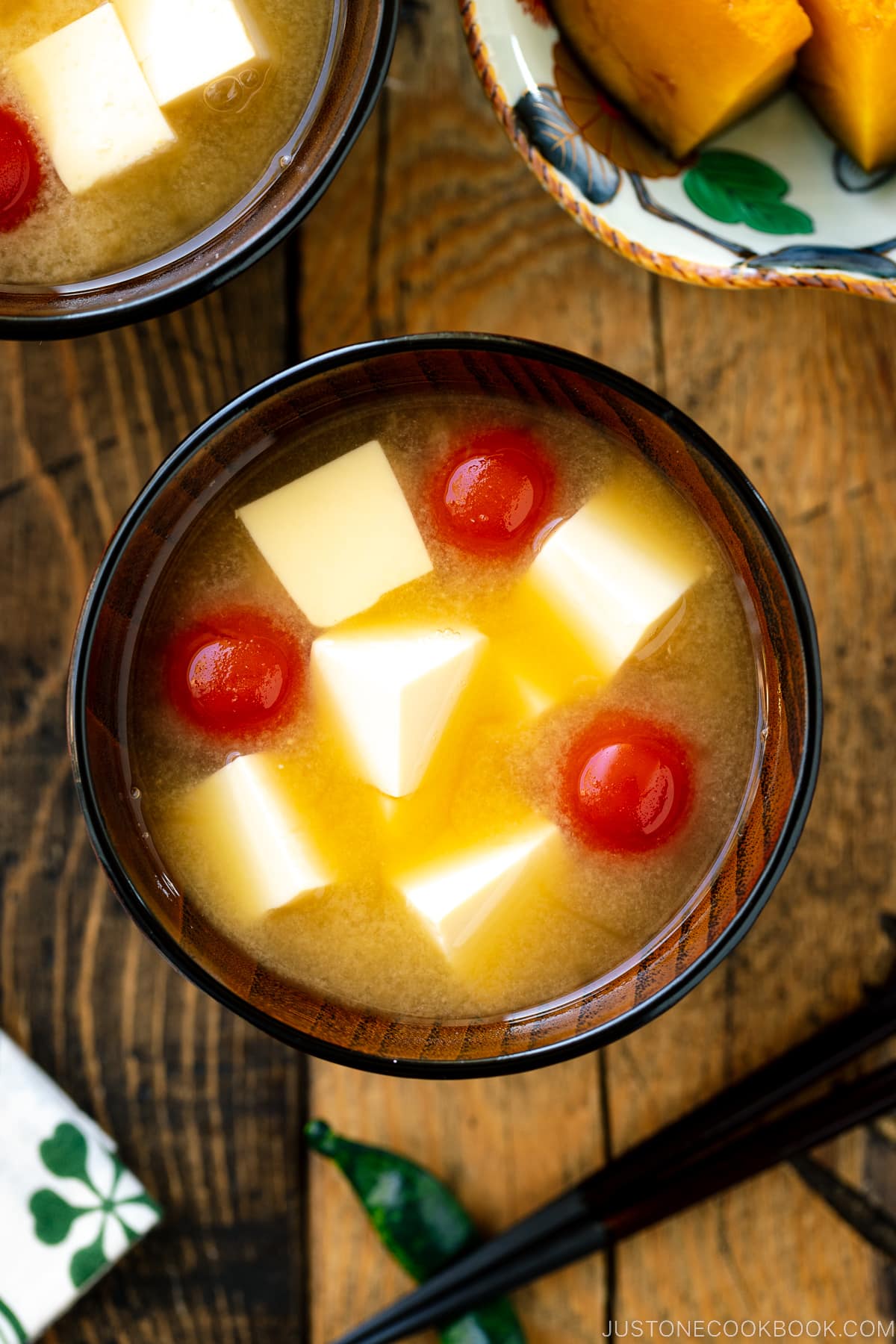 A Japanese wooden bowl containing Tomato and Tofu Miso Soup.