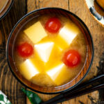 A Japanese wooden bowl containing Tomato and Tofu Miso Soup.