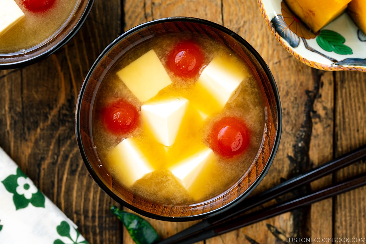 A Japanese wooden bowl containing Tomato and Tofu Miso Soup.