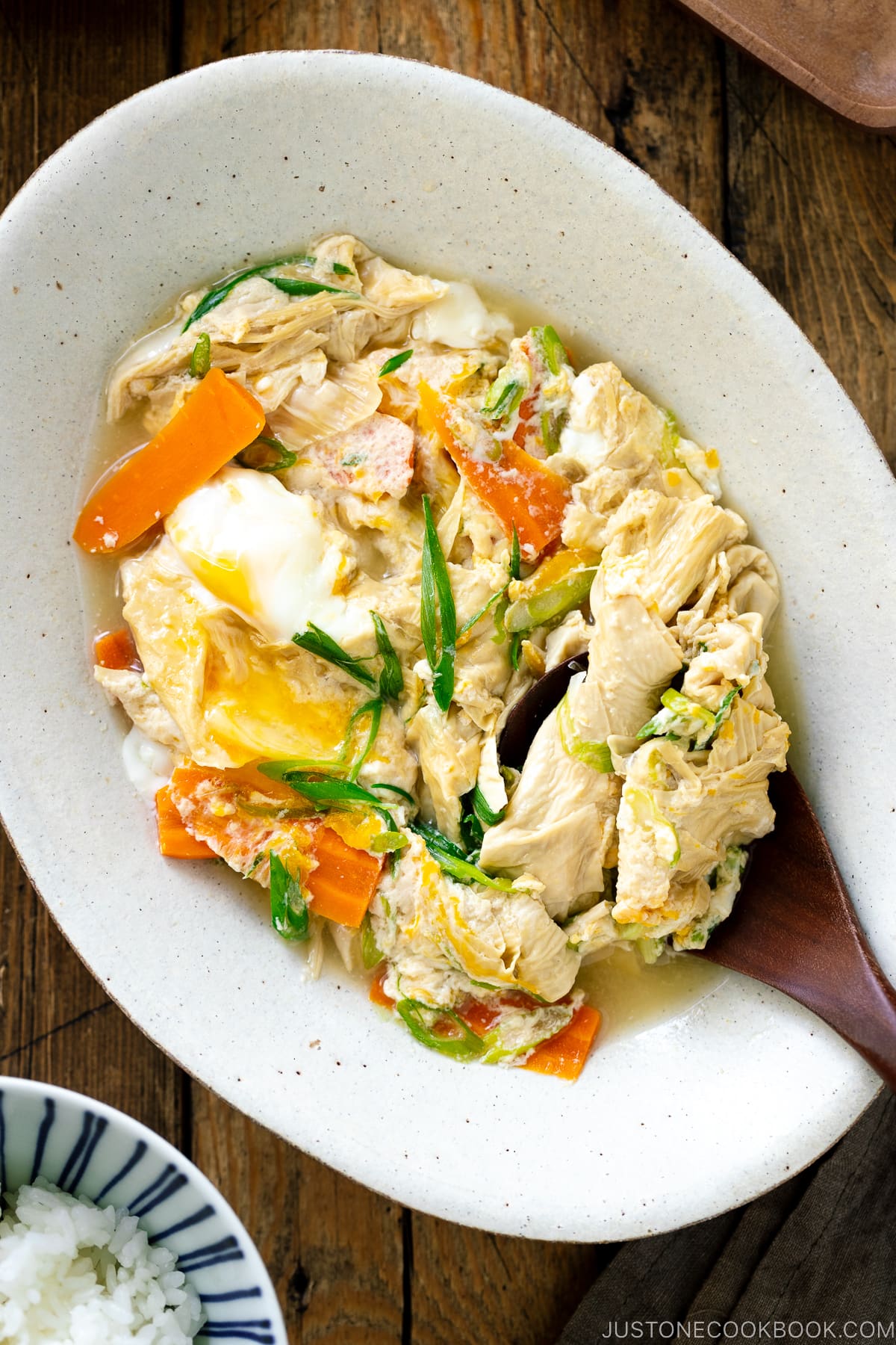 A white ceramic bowl contaiing Yuba Tamagotoji (Simmered Tofu Skin with Soft Scrambled Eggs).