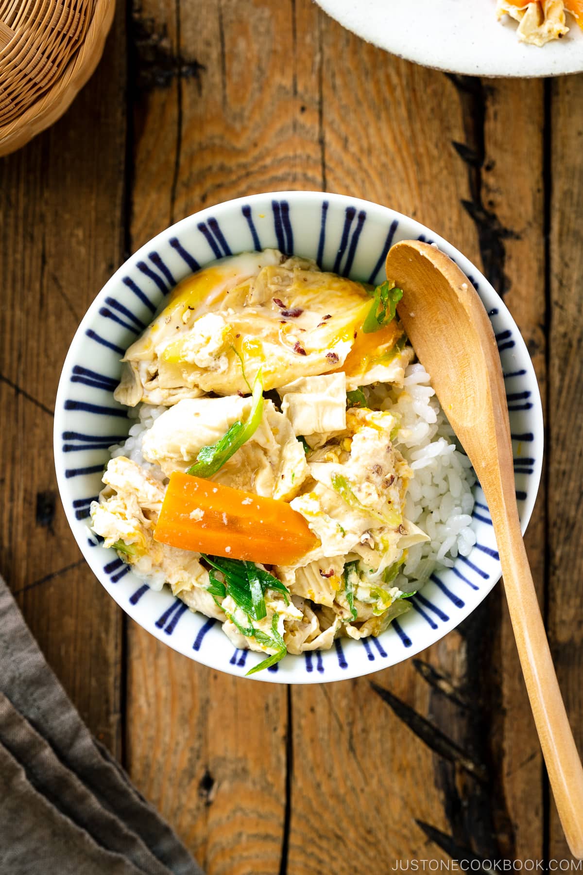 A white ceramic bowl contaiing Yuba Tamagotoji (Simmered Tofu Skin with Soft Scrambled Eggs).