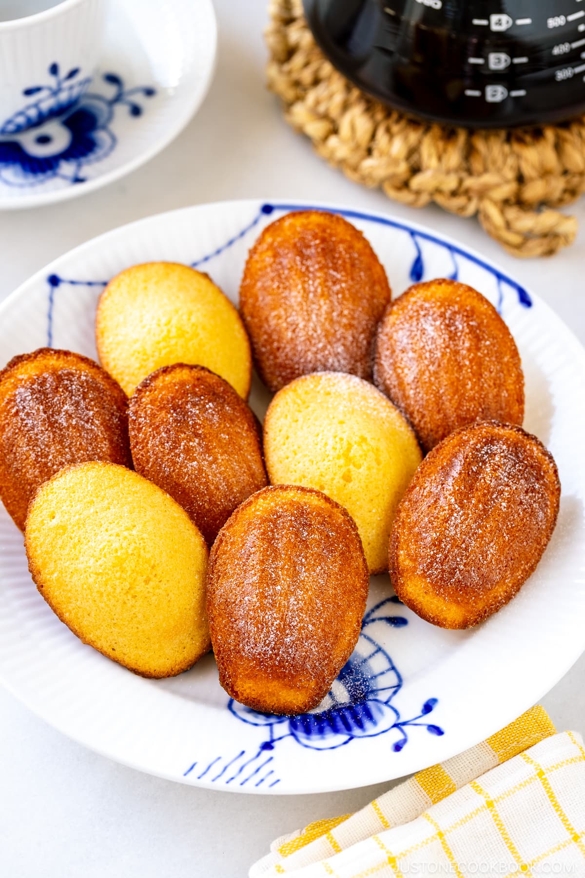 A Royal Copenhagen plate containing Madeleines dusted with powdered sugar.