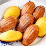 A Royal Copenhagen plate containing Madeleines dusted with powdered sugar.