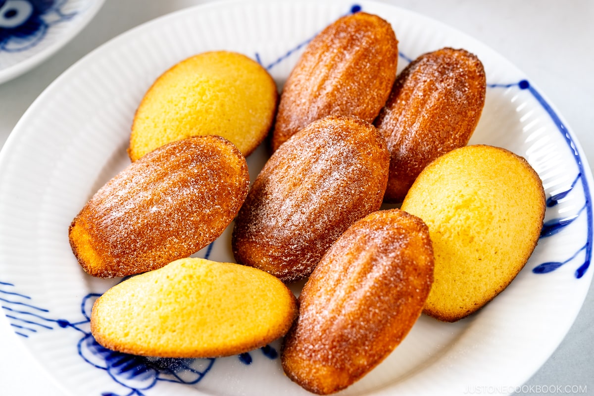 A Royal Copenhagen plate containing Madeleines dusted with powdered sugar.