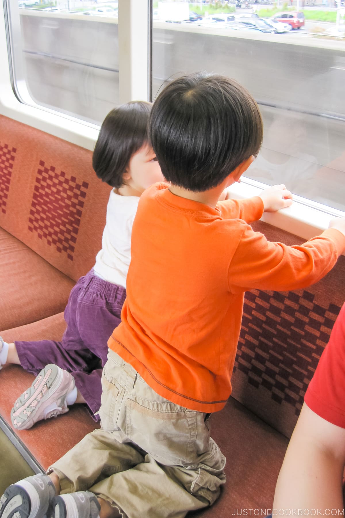 a boy and a girl looking out the train window