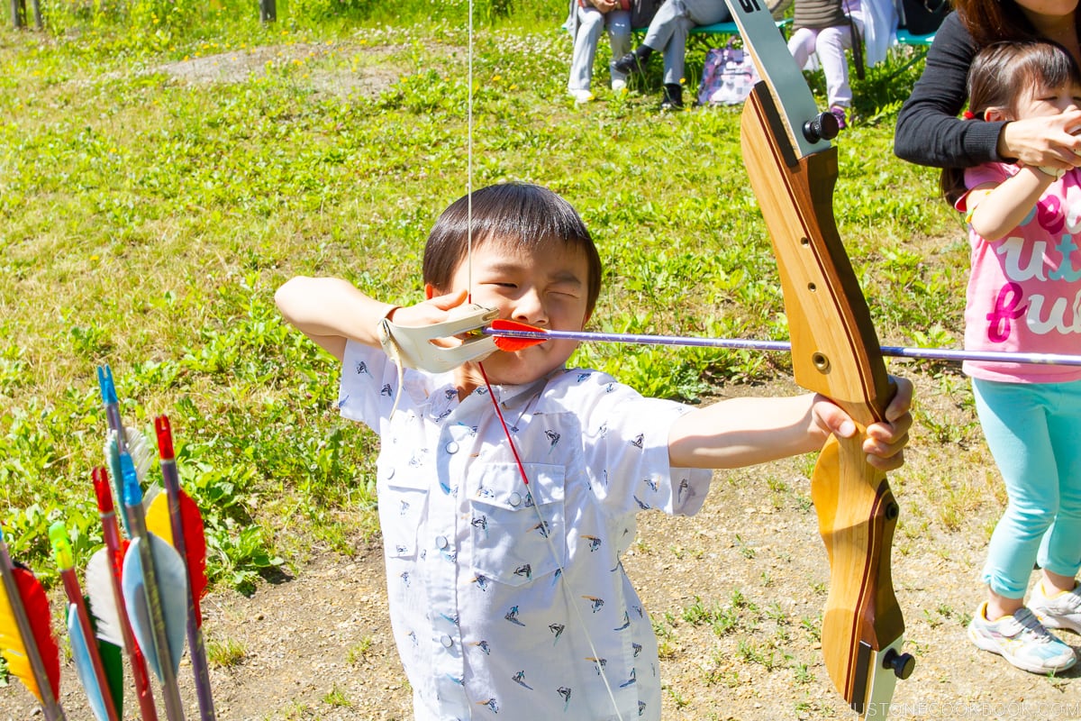 a boy shooting an arrow from a bow
