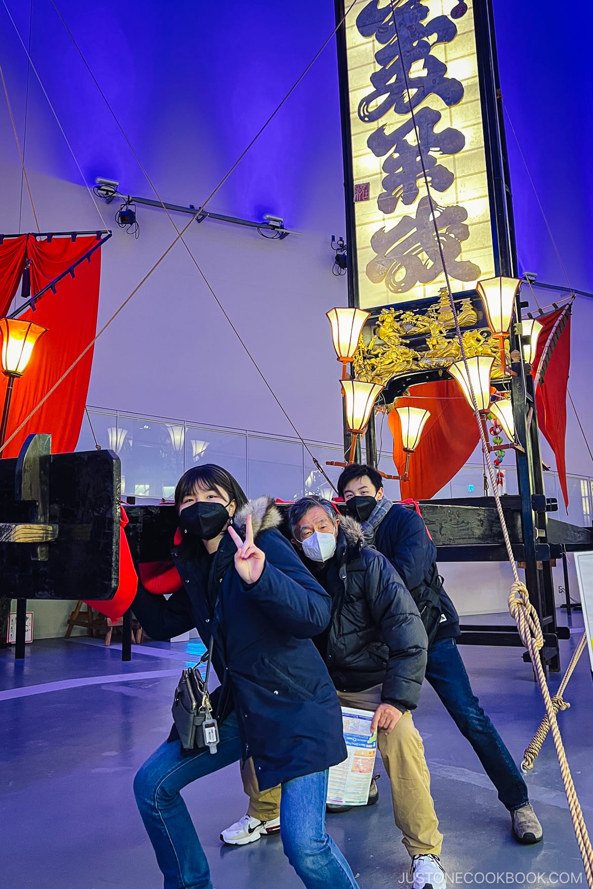 three people standing in front of a Wajima Kiriko lantern