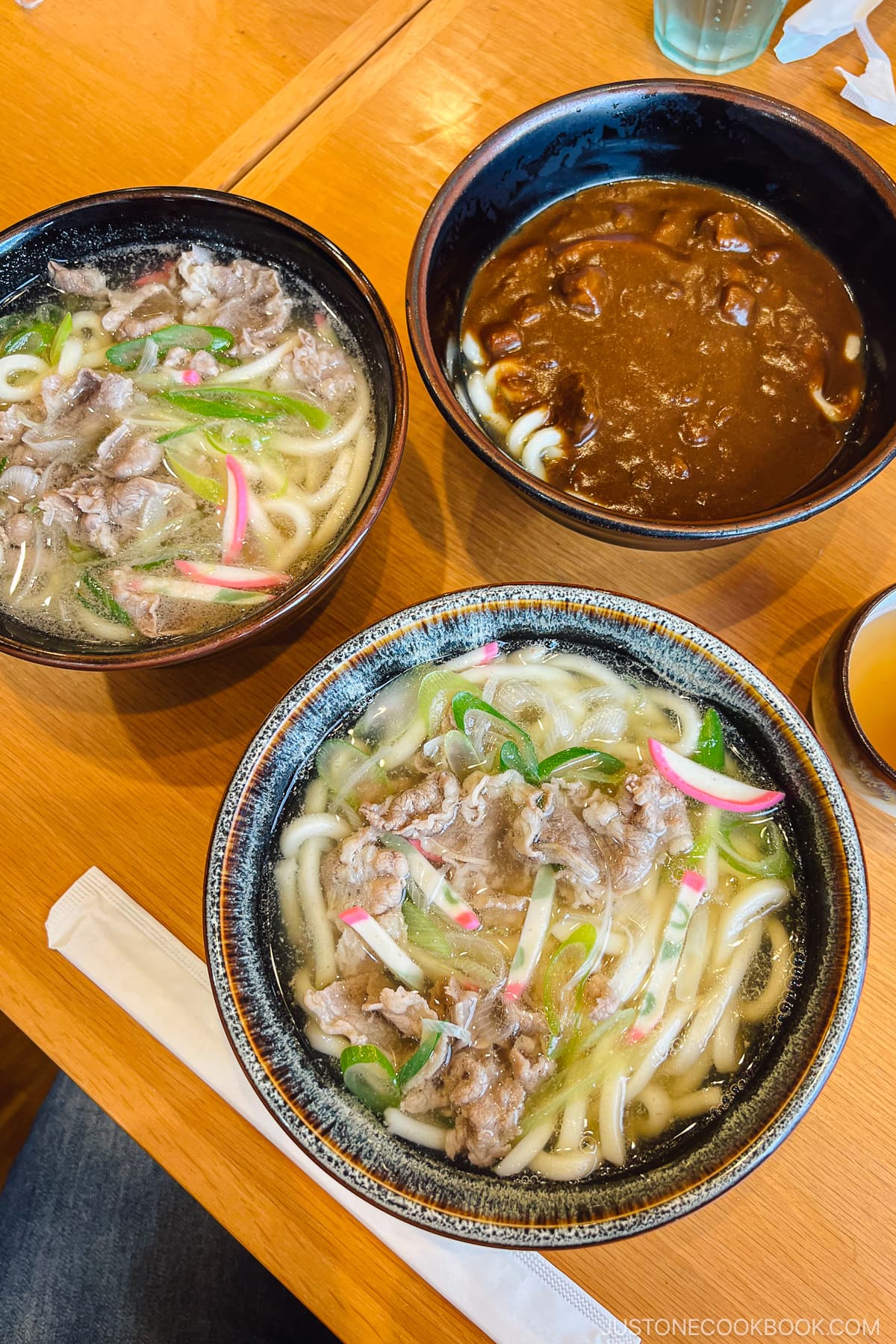 three bowls of udon on a table